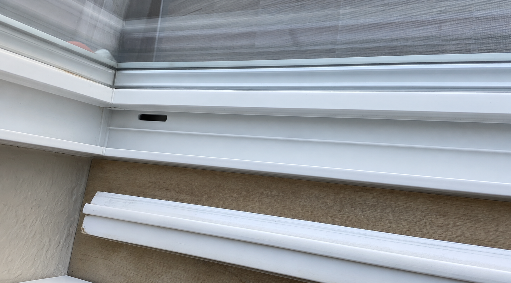 Window track after deep cleaning: spotless white rails and channels, screen corner gleaming
